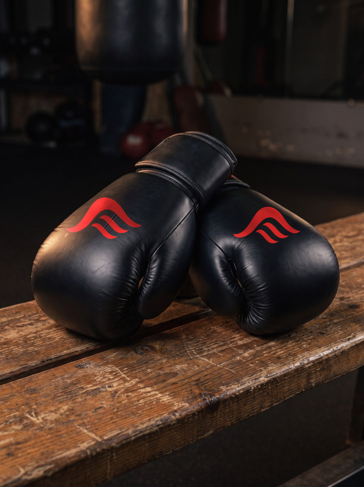 Fyrefit Boxing Gloves (Black), resting on a gym bench