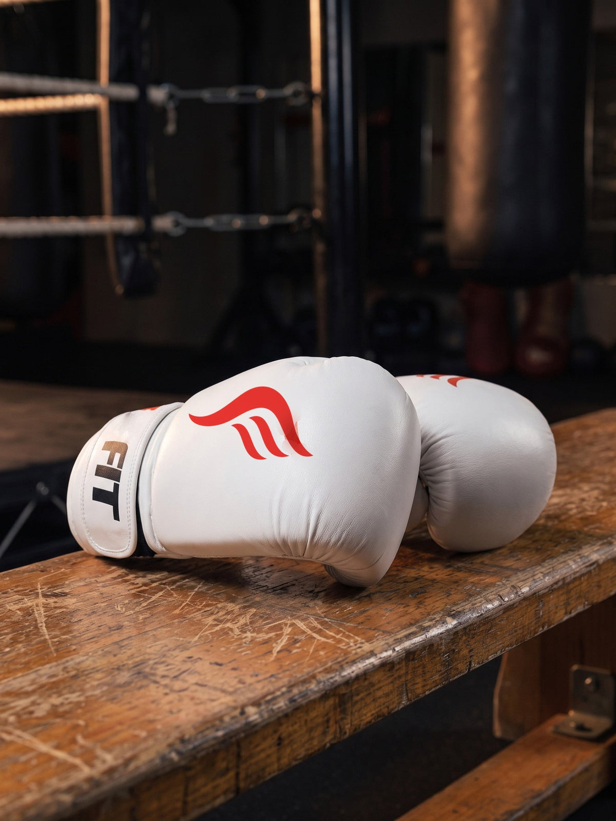 Fyrefit Boxing Gloves (White), resting on a gym bench