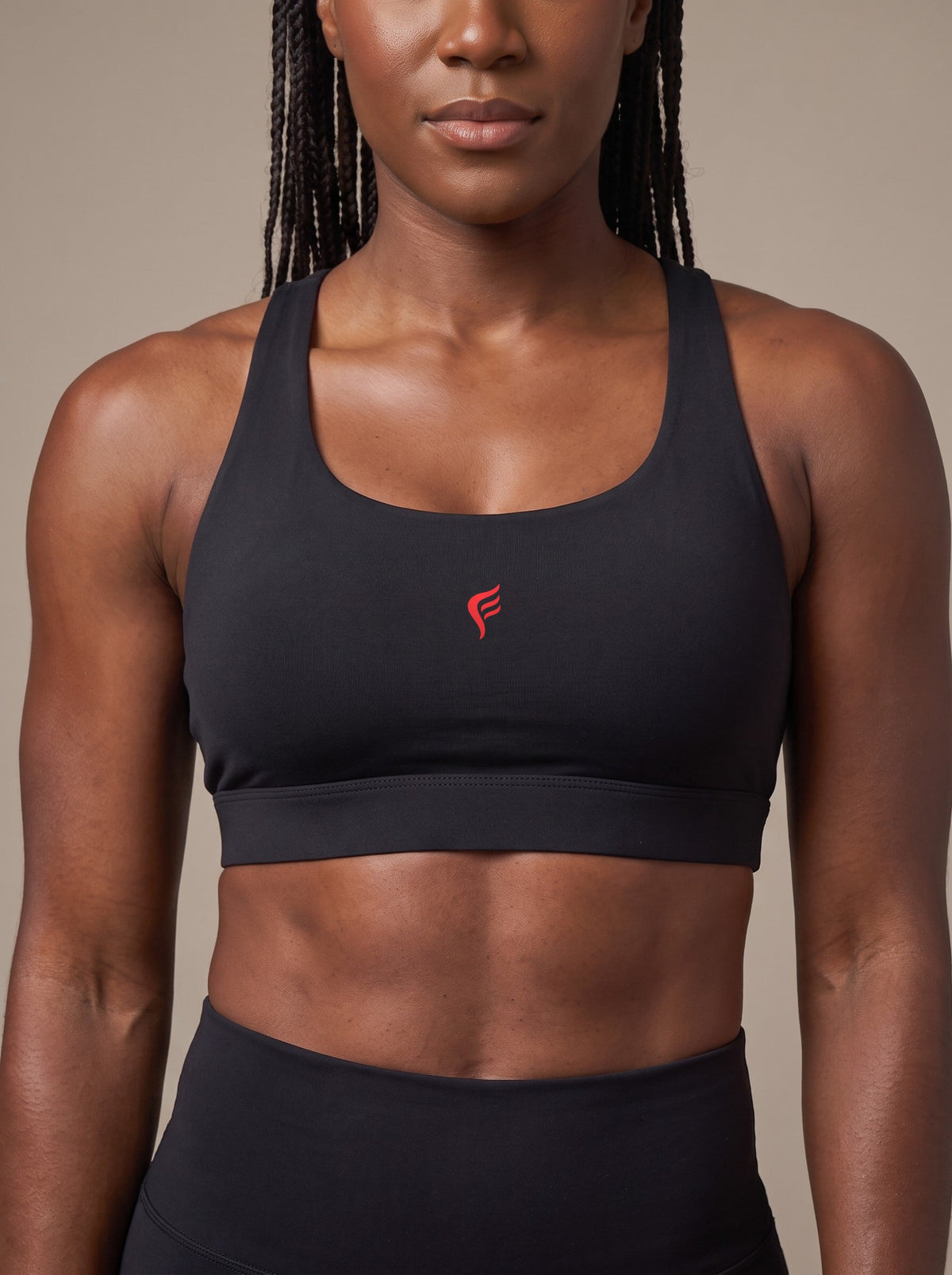 Women's Racerback Sports Bra in Black, chest logo close-up